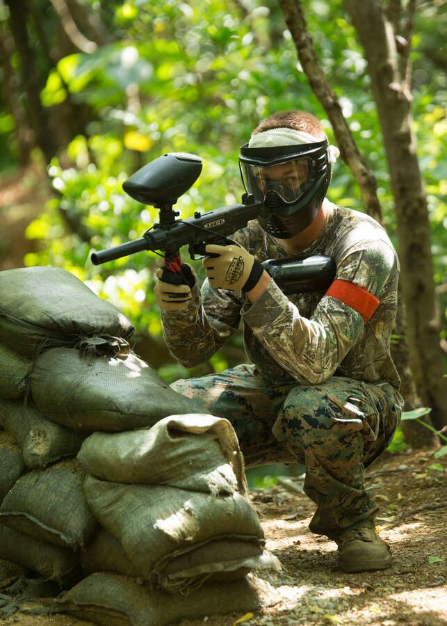 Lance Cpl.  Derick Johnson finds cover behind sandbags during a paintball tournament at White Beach, Okinawa, Japan, May 20, 2016. The tournament, hosted by the Single Marine Program, turned into a competition between engineer and motor transport Marines from Camp Hansen and Camp Courtney. (U.S. Marine Corps photo by Lance Cpl. Amaia Unanue/ Released)