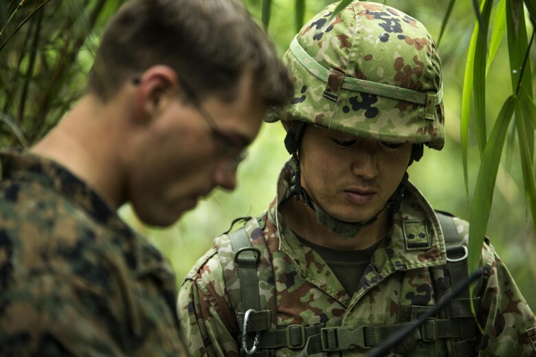 Japanese Military Lt. Kino speaks to U.S. Marine Sgt. Matthew Myers during the 5-day Course at Jungle Warefare Training Center, Camp Gonsalves, Okinawa, Japan, May 19, 2016. The JSTF observed 9th Engineer Support Battalion, 3rd Marine Logistics Group, III Marine Expeditionary Force, while they complete the 5-day Course. The 5-day course gives Marines the skills to shoot, move and communicate in a jungle environment. The JSTF potentially wants to join the Marines on the training base so that the two forces can work together effectively in the jungle terrain. (U.S. Marine Corps photo by Lance Cpl. Amaia Unanue/ Released)