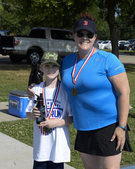A mother and her son pose for a photo after the Armed Forces Kids’ Run at Barksdale Air Force Base, La., May 21, 2016. Each child who participated received a t-shirt and a medal upon completing their race. (U.S. Air Force photo/Airman 1st Class Stuart Bright)