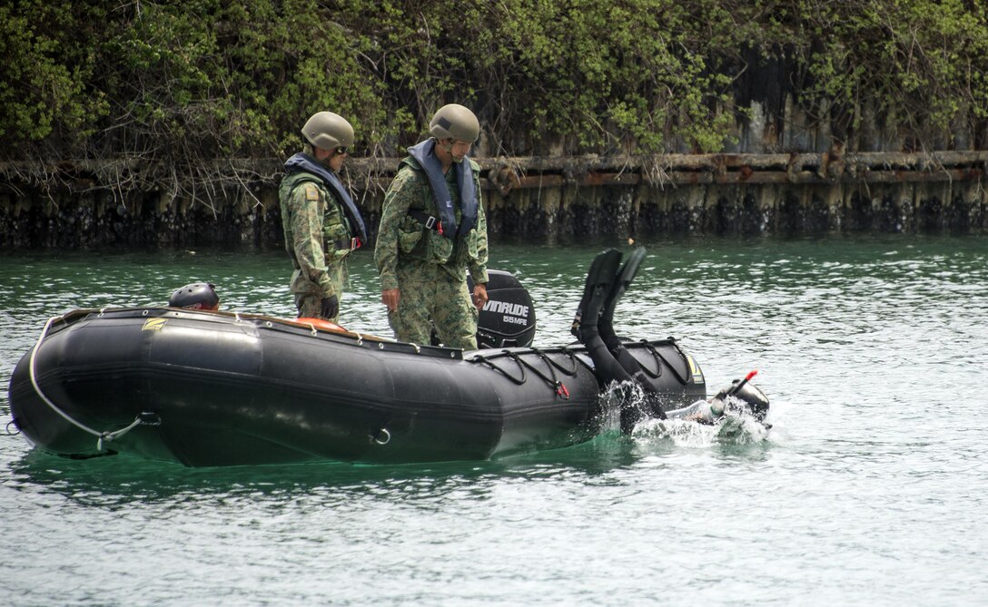 A Singapore explosive ordnance disposal technician enters the water during a limpet mine training operation as part of exercise Tricrab at Naval Base Guam, May 18, 2016. Navy photo by Petty Officer 3rd Class Alfred A. Coffield
