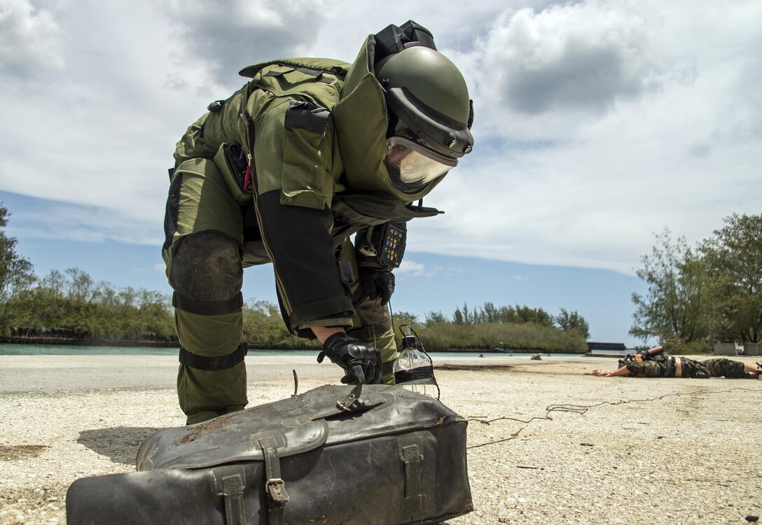 A Canadian explosive ordnance disposal technician inspects an improvised explosive device during a training scenario as part of exercise Tricrab at Naval Base Guam, May 18, 2016. Navy photo by Petty Officer 3rd Class Alfred A. Coffield