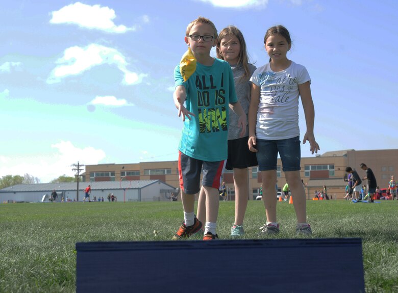 Dominic Bellerdine, Summer Black, and Skie Seggerman, Ellicott Elementary School students, play a round of bean bag toss at a field days event in Ellicott, Colorado, Tuesday, May 24, 2016. Children participated in numerous activities, such as sack racing, long jumping and a homemade obstacle course. (U.S. Air Force photo/Airman William Tracy)