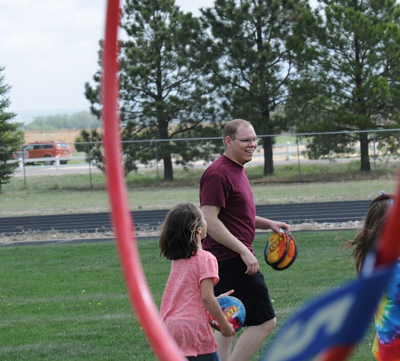 Senior Airman Derrick Nicholson, 4th Space Operations Squadron, plays disc golf with Ellicott Elementary School students at a field days event in Ellicott, Colorado, Tuesday, May 24, 2016. Nicholson and other volunteers participated with the children in the event’s various stations. (U.S. Air Force photo/Airman William Tracy)