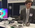 NATIONAL HARBOR, Md. (May 17, 2016) - Navy engineer Steve Price briefs 2016 Sea-Air-Space Expo attendees on the small additively manufactured modular payload multi-rotor. This low cost, 3D printed, unmanned aerial vehicle can accept a wide variety of custom payloads. The UAV was one of the exhibits featured at the Navy Additive Manufacturing Showcase in Dahlgren, Va., last month that were selected for display at the Sea-Air-Space Expo. "The volume of creative and innovative ideas made feasible with 3D Printing is astounding," said Lynn Shoppell, a Naval Surface Warfare Center Dahlgren Division physicist after the Dahlgren showcase. "The exhibitors demonstrated that their concepts for increased technical capabilities, rapid prototyping, improved logistics operations, and cost reduction initiatives are achievable with 3D Printing. Participants also experimented with additive manufacturing technology research and development."