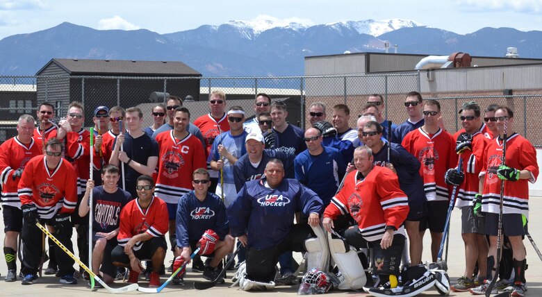 Members of both the U.S. and Canadian ball hockey teams gather following the third annual U.S. vs. Canada Ball Hockey Tournament at Peterson Air Force Base, Colorado, Friday, May 20, 2016. The annual event serves as a morale and camaraderie building opportunity between the two forces. Canada retained the championship with a 4-3 victory. The U.S. team comprises members from the 21st and 50th Space Wings and 721st Mission Support Group. (U.S. Air Force photo/Brian Hagberg)