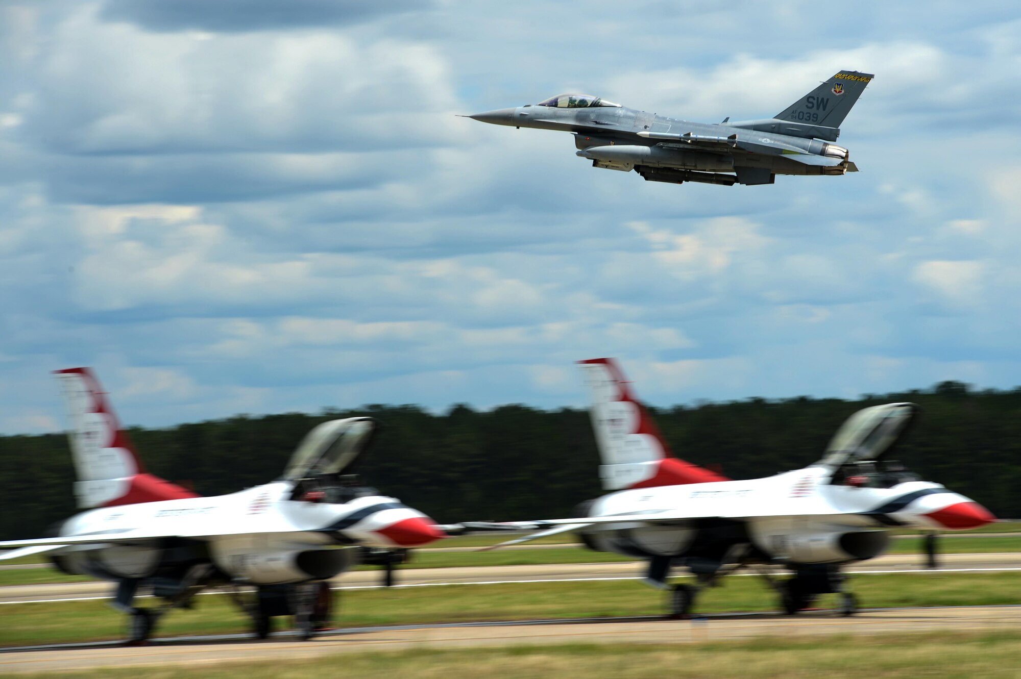 An F-16CM Fighting Falcon assigned to the 79th Fighter Squadron flies over U.S. Air Force Air Demonstration Squadron jets at the Shaw Air Expo and open house, May 22, 2016, at Shaw Air Force Base, S.C. The F-16 flew with three other F-16’s, two A-10 Thunderbolt II’s and several AH-64 Apaches and UH-60 Black Hawks as part of a combined forces combat airpower demonstration. (U.S. Air Force photo by Senior Airman Jonathan Bass)