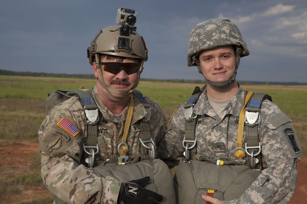 Army Chief Warrant Officer 5 Thomas Travis, left, a rotary wing advisor and pilot with U.S. Army Special Operations Aviation Command, and his son Pvt. Joshua Travis, a parachute rigger, prepare to board a UH-60 helicopter for a jump on St. Mere Eglise Drop Zone at Fort Bragg, N.C., during the Law Day Airborne Operation, May 5, 2016. Army photo by Spc. Rachel Diehm