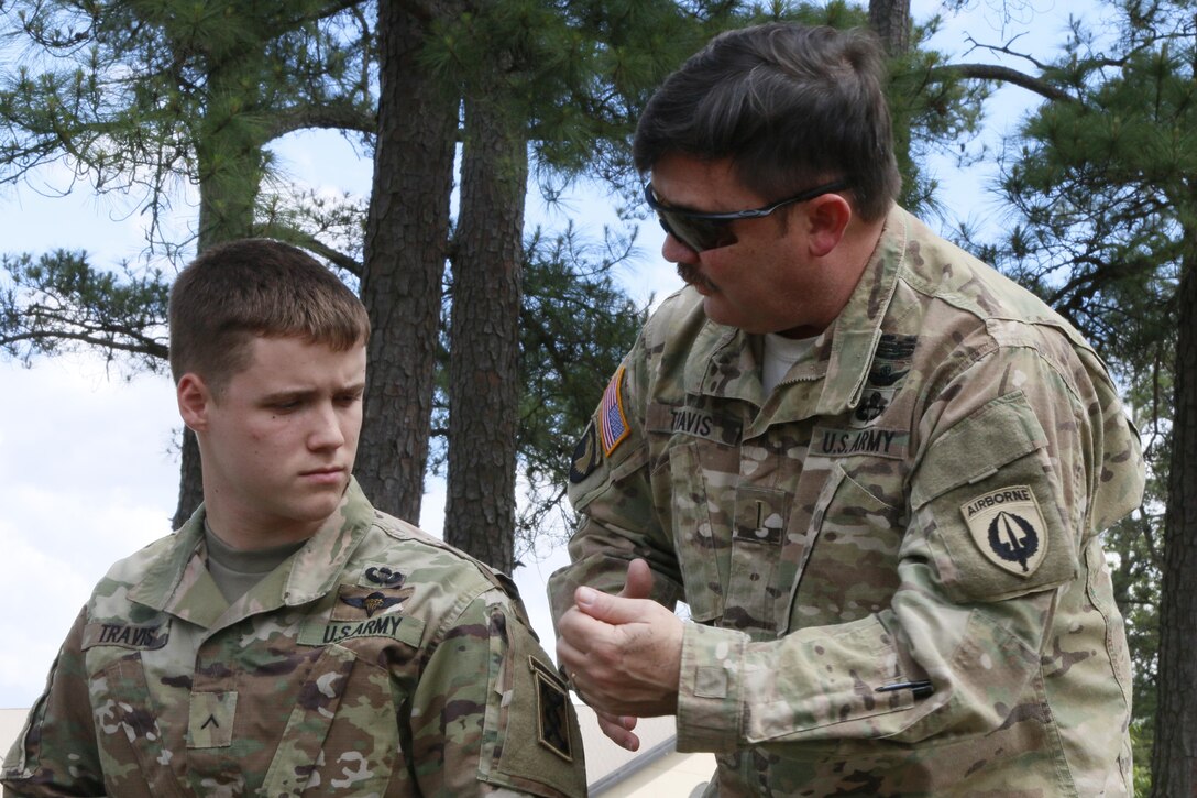Army Chief Warrant Officer 5 Thomas Travis, right, a rotary wing advisor and pilot with U.S. Army Special Operations Aviation Command, and his son Pvt. Joshua Travis, a parachute rigger, discuss the procedures for their upcoming jump from a UH-60 helicopter at Fort Bragg, N.C., during the Law Day Airborne Operation, May 5, 2016. Army photo by Spc. Rachel Diehm