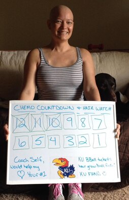 Laura Markuly, a 349th Air Refueling Squadron administration assistant, holds a poster showing her progression during her chemotherapy treatment in Wichita, Kan. Markuly educates others on how to live healthfully through her Facebook page and blog where she shares exercises and nutritional facts. (Courtesy photo)