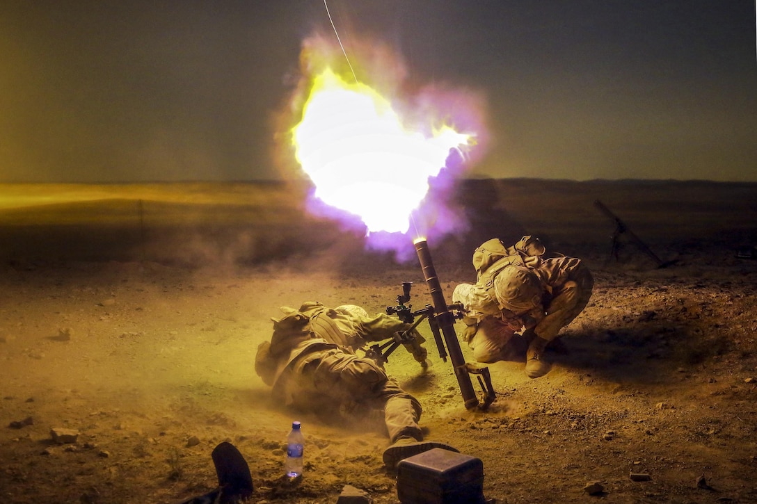 Marine Lance Cpl. Zach King, left, and Cpl. Derick Sammonek brace themselves as an 60mm mortar exits the tube of an M224 mortar system as part of sustainment training during Exercise Eager Lion 2016 in Jordan, May 15, 2016. The exercise enables partner nations to exchange military expertise and improve interoperability. Marine Corps photo by Sgt. Paris Capers