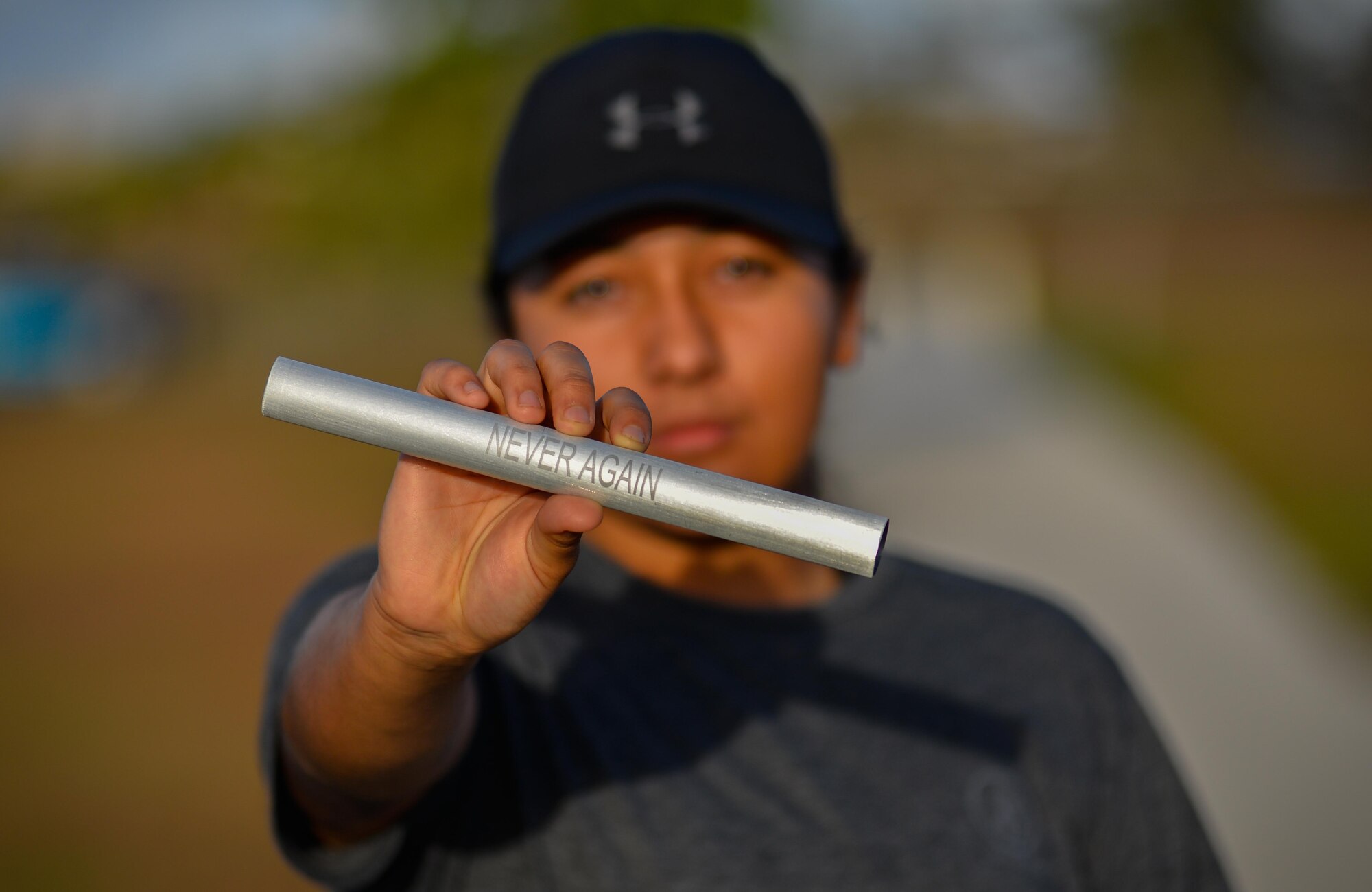 Airman 1st Class Jasmine Mora, munitions operations technician with the 36th Munitions Squadron, holds a rememberance baton during the Holocaust Memorial Walk May 26, 2016, at Andersen Air Force Base, Guam. The baton was ingraved with the inscription "Never Again - In Rememberance" to raise awareness of the stories of victims who suffered under the Nazi Regime in Germany 1933-1945. (U.S. Air Force photo by Staff Sgt. Alexander W. Riedel/Released)