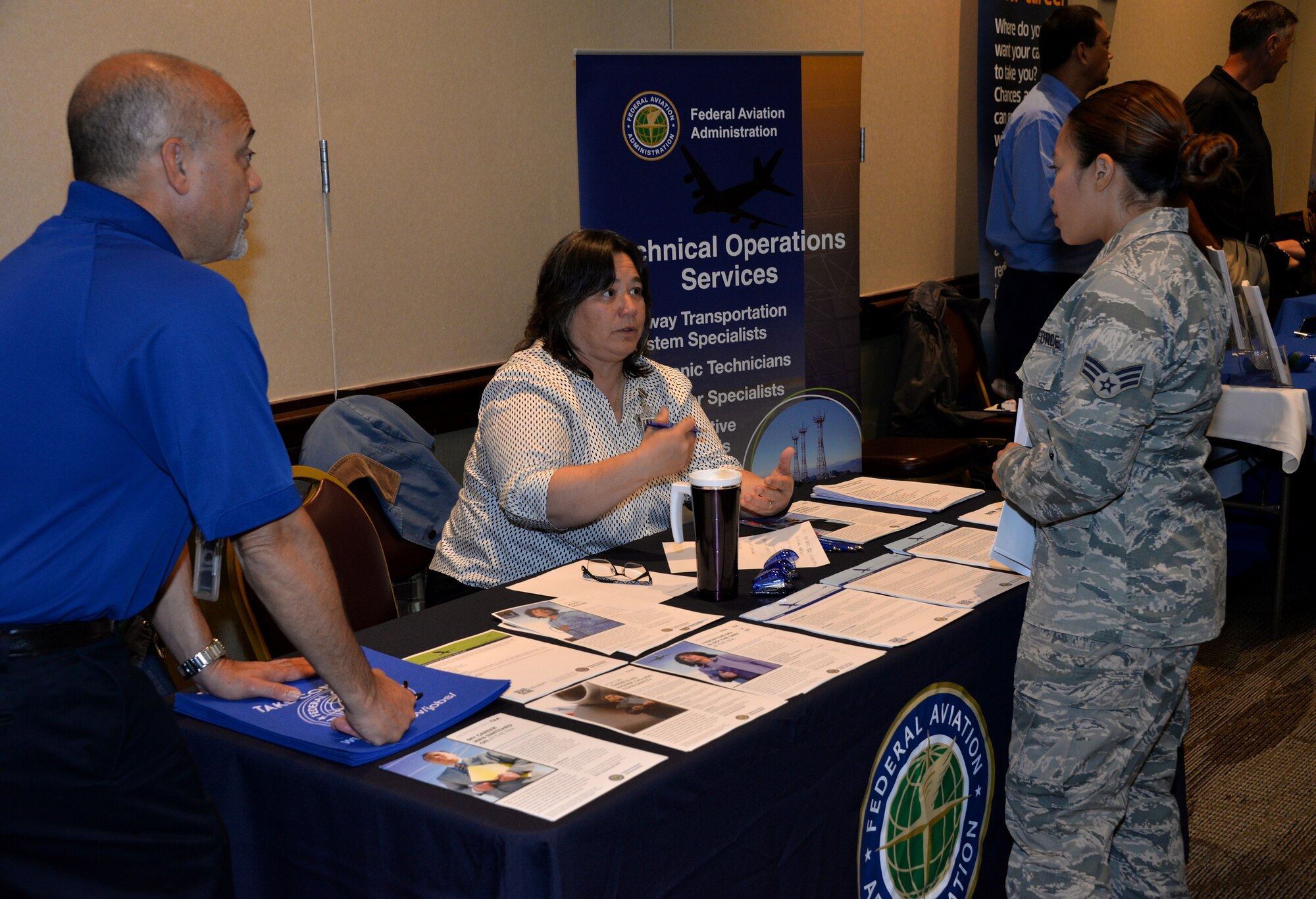 An Airman assigned to Travis Air Force Base talks with representatives from the Federal Aviation Administration during the Education and Career Fair at Travis Air Force Base, Calif., May 22, 2016. More than 110 people attended the fair with a handful of individuals being hired on the spot. (U.S. Air Force photo by Staff Sgt. Charles Rivezzo)
