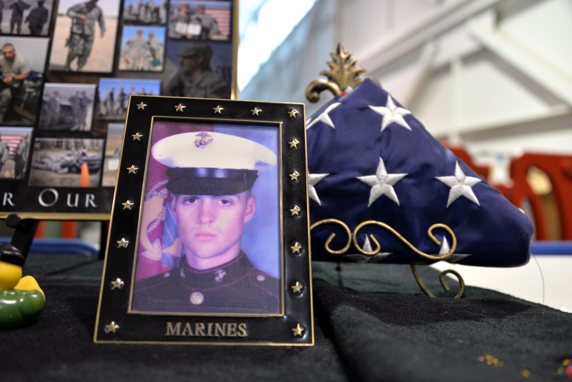 A picture of a fallen service member sits on one of several display tables at the Gold Star Families Ruck March at Travis Air Force Base, Calif., May 21, 2016. Approximately 200 service members participated in the sixth annual GSFRM, honoring the more than 45 Gold Star family members who were in attendance. (U.S. Air Force photo by Staff Sgt. Charles Rivezzo)