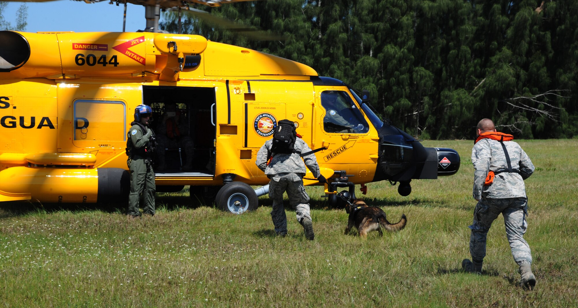Senior Airman Austin Cook, a military working dog (MWD) handler, and Airman First Class Lake Rabel, an entry controller, both assigned to the 6th Security Forces Squadron (SFS) escort MWD Lleonard onto an MH-60T Jayhawk during a helicopter training exercise with the U.S. Coast Guard Air Station in Clearwater, Fla., May 23, 2016. The 6th SFS partnered with the Coast Guard to conduct a helicopter training exercise to acclimate the dogs to the loud noise and high altitude. (U.S. Air Force photo by Airman Adam R. Shanks)