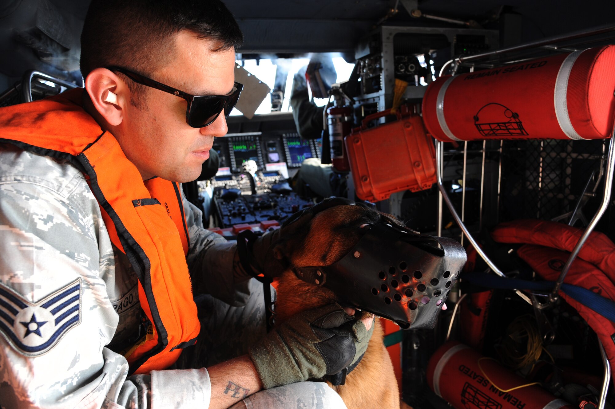 Staff Sgt. Corey Ray Alpago, military working dog (MWD) handler with the 6th Security Forces Squadron (SFS), comforts MWD Lleonard in an MH-60T Jayhawk midflight over the U.S. Coast Guard Air Station in Clearwater, Fla., May 23, 2016. The 6th SFS partnered with the Coast Guard to provide helicopter training exercises for the MWDs to expose them to the loud noise and high altitude. (U.S. Air Force photo by Airman Adam R. Shanks)