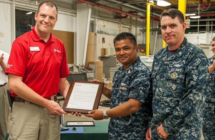 Todd Musselman (left) from the American Red Cross presents a letter of appreciation to  Sailors from the Naval Nuclear Power Training Unit Charleston community service division May 20, 2016, at Joint Base Charleston, S.C. More than 100 Sailors transitioning through the community service division, have volunteered nearly 10,000 hours in support of local nonprofit organizations since the program began October 2015. The program, created for Sailors on hold from NPTU and awaiting orders due to medical, legal or other reasons, provides the opportunity to give back to the local community while resolving personal matters. (U.S. Air Force photo/Staff Sgt. Jared Trimarchi) 