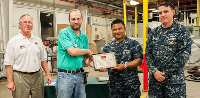 Dennis Tony and Kevin Gravely (left) from the Lowcountry Food Bank present a certificate of appreciation to sailors from the Naval Nuclear Power Training Unit Charleston community service division May 20, 2016, at Joint Base Charleston, S.C. More than 100 Sailors transitioning through the community service division volunteered nearly 10,000 hours in support of local nonprofit organizations since the program began October 2015. The program, created for Sailors on hold from NPTU and awaiting orders due to medical, legal, or other reasons, provides the opportunity to give back to the local community while resolving personal matters. (U.S. Air Force photo/Staff Sgt. Jared Trimarchi) 