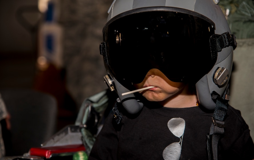 A Minot Youth Center member tries on a pilot’s helmet during operation heroes at Minot Air Force Base, N.D., May 21, 2016. During operation heroes, kids got to experience many different jobs of the Air Force such as pilots, security forces, maintenance and others. (U.S. Air Force photo/Airman 1st Class Christian Sullivan)