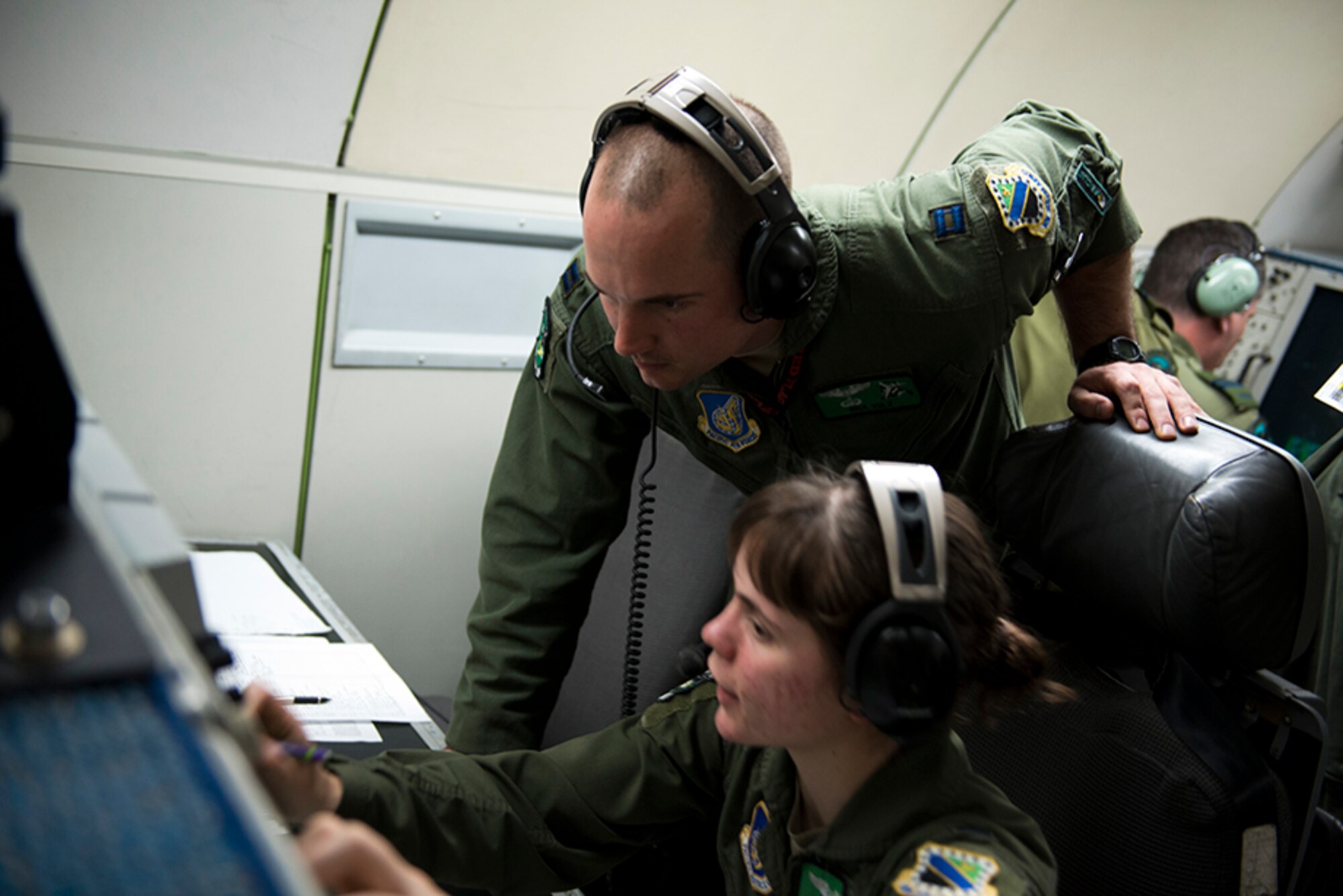 Air Force Capt. Nick Volz, an airborne weapons officer assigned to the 3rd Operational Support Squadron consults with another airborne weapons officer on board an E-3 Sentry Airborne Warning and Control System during the last Red Flag-Alaska 16-1 sortie May 12. Red Flag-Alaska is a Pacific Air Forces commander-directed field training exercises for U.S. and international forces that provides combined offensive counter-air, interdiction, close air support and large force employment training in a simulated combat environment. (U.S. Air Force photo by Senior Airman Kyle Johnson