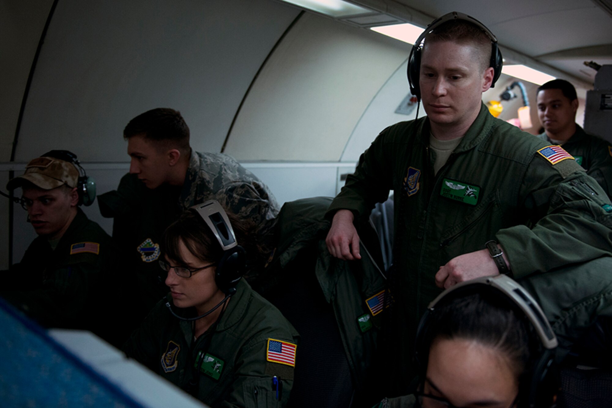 Air Force Staff Sgt. Justin Burke. A 962nd Airborne Air Control Squadron air surveillance technician, watches over the air surveillance technicians as they busily work through their tasks during the heat of the simulated conflict on board an E-3 Sentry Airborne Warning and Control System for the final sortie of Red Flag-Alaska 16-1, May 12. Red Flag-Alaska is a Pacific Air Forces commander-directed field training exercises for U.S. and international forces that provides combined offensive counter-air, interdiction, close air support and large force employment training in a simulated combat environment. (U.S. Air Force photo by Senior Airman Kyle Johnson)