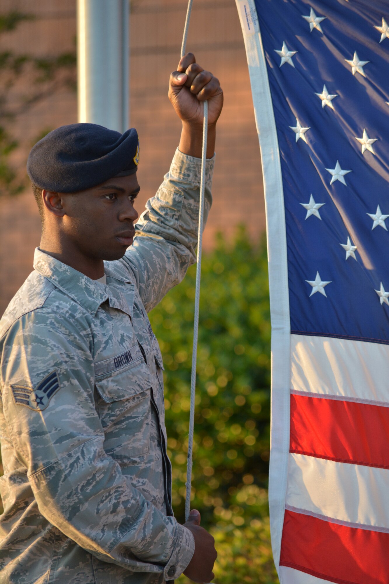 Senior Airman Nicholas Brown, 78th Security Forces Squadron alarm monitor, raises the flag during Reveille May 16 as part of Police Week events on Robins. (U.S. Air Force photo by Kenya Askew)