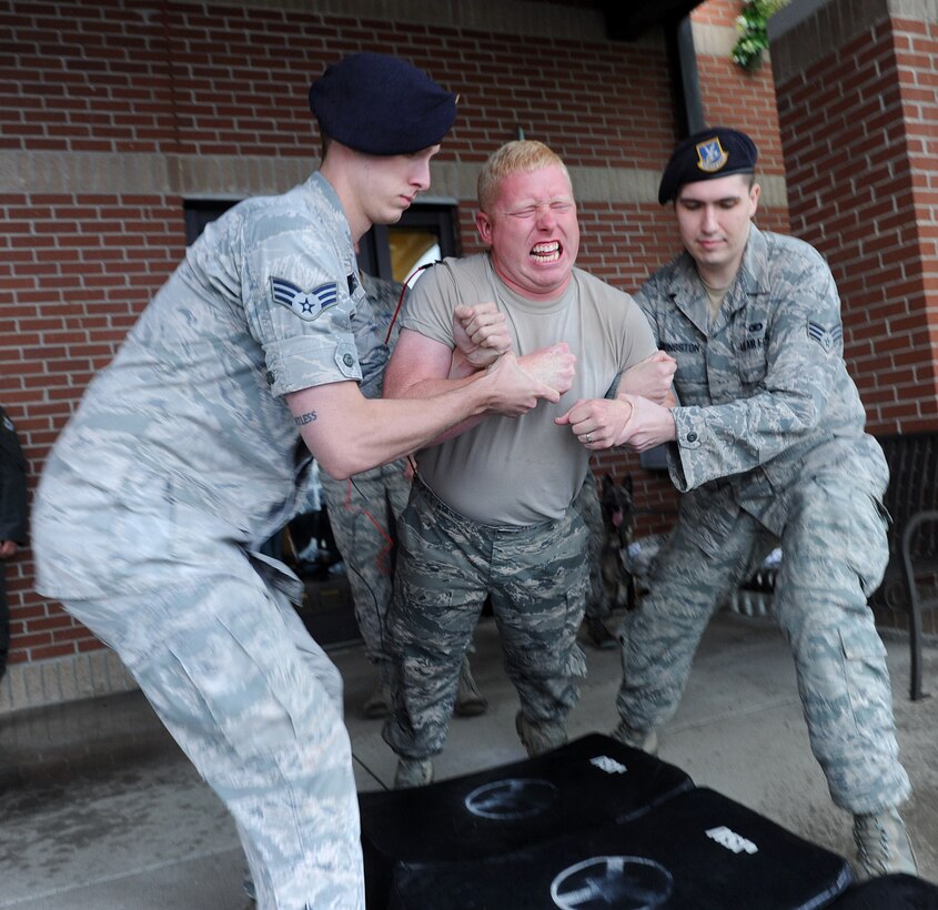 Senior Airman Seth Wilson is supported by Senior Airman Jonathan Reinersmann, left, and Senior Airman Shane Livingston during a taser demo, May 17. (U.S. Air Force photo by Tommie Horton)