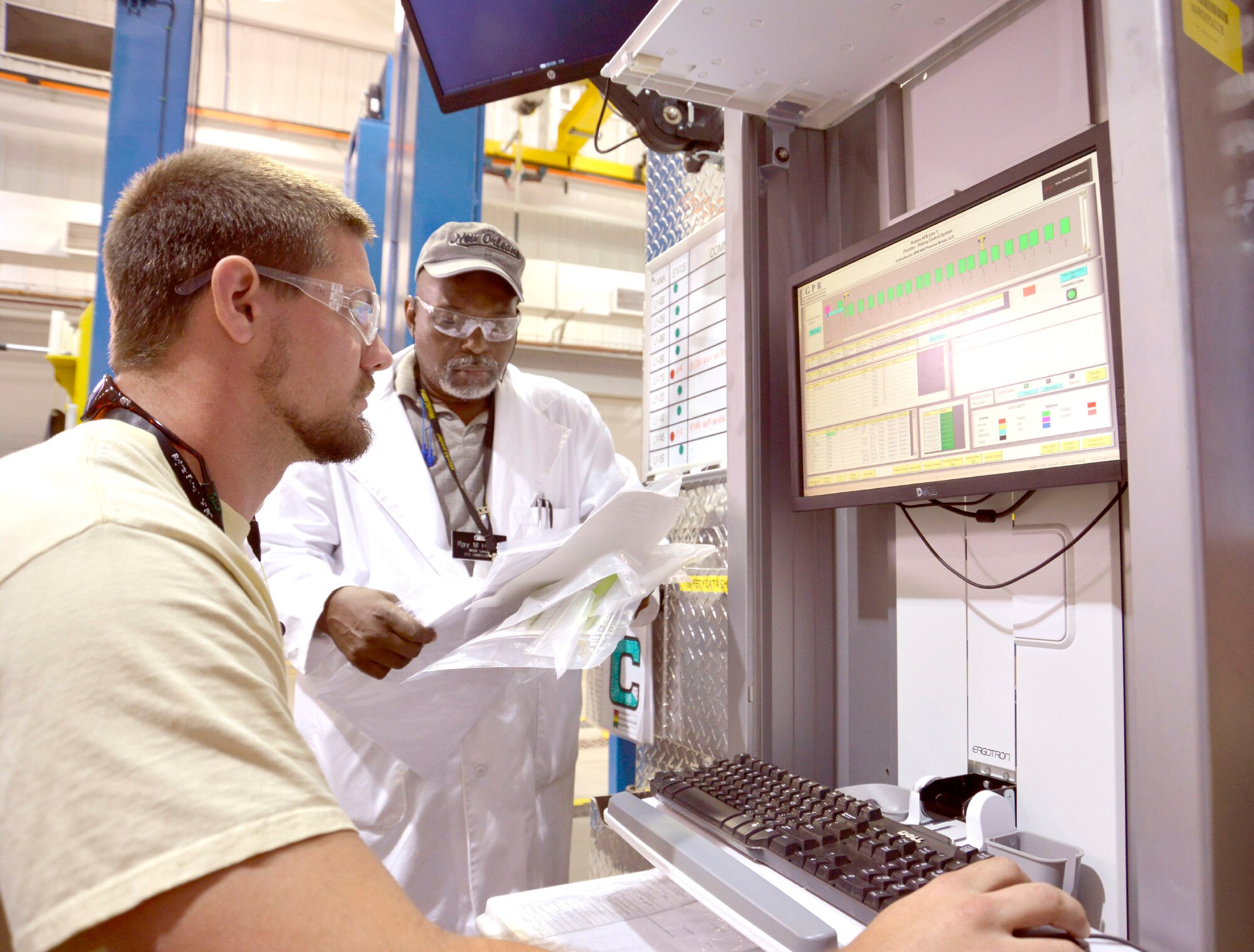 Tyler Mackey, metallizer, seated, and Ray Henley, work leader, both with the 402nd Commodities Maintenance Group, prepare aluminum components for the cleaning and conversion coating processes in Bldg. 20128. (U.S. Air Force photo by Ed Aspera)