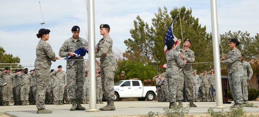 Members of the 412th Security Forces Squadron lower the American Flag and the Defensor Fortis (Air Force Security Forces) flag during a special retreat ceremony marking the end of Police Week. (U.S. Air Force photo by Christopher Ball.)
