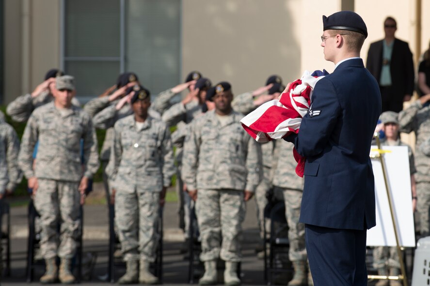 Airman 1st Class Brandon Lemmon, 374th Security Forces Squadron patrolman, carries the American Flag during a retreat ceremony May 19, 2016 at Yokota Air Base, Japan. The security forces-lead ceremony wrapped up the squadron’s National Police Week activities while giving them the opportunity to mourn their fallen Military Working Dog Alan/L220 who recently passed away from cancer. (U.S. Air Force photo by Yasuo Osakabe/Released)