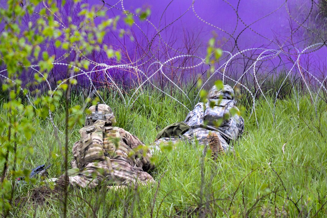 Soldiers assess a concertina wire obstacle under the cover of smoke and prepare to breach it using a bangalore torpedo during their Gunnery Table XII at Grafenwoehr Training Area, Germany, May 19, 2016. The soldiers are combat engineers assigned to the 3rd Infantry Division’s 10th Engineer Battalion, 1st Armored Brigade Combat Team. Army photo by Maj. Randy Ready