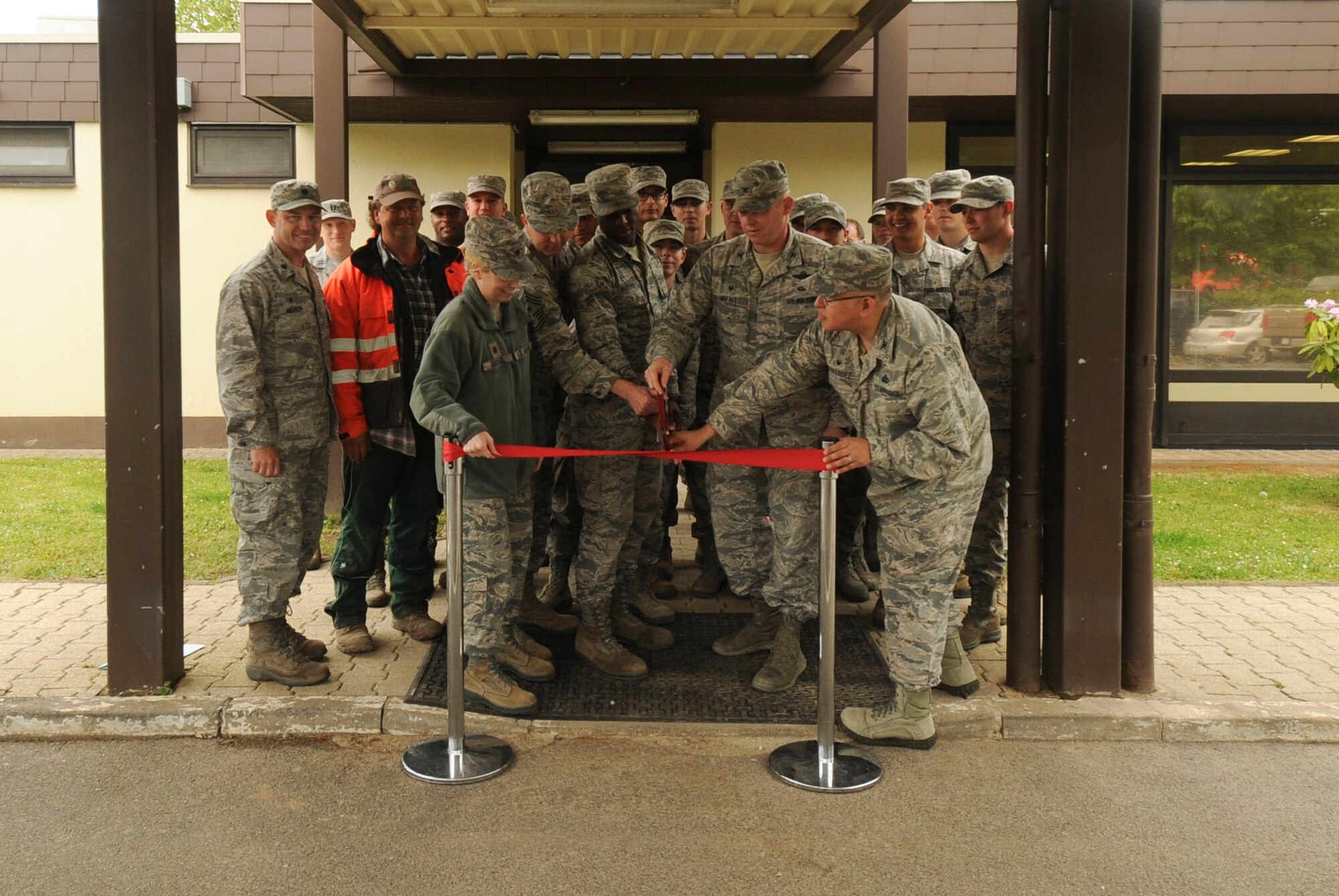 U.S. Air Force Col. Joe McFall, 52nd Fighter Wing commander, center right, and Airmen assigned to the 52nd FW prepare to cut a ribbon during the opening ceremony of the Saber Pet Lodge at Spangdahlem Air Base, Germany, May 23, 2016. The wing constructed the facility with non-appropriated funds generated through patrons of the base exchange. (U.S. Air Force photo by Staff Sgt. Joe W. McFadden/Released)