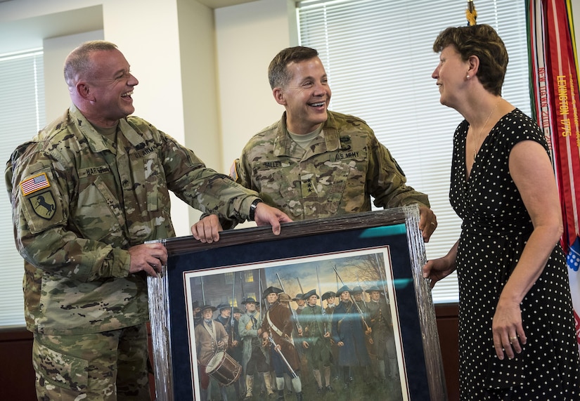 Brig. Gen. Robert Harter, chief of staff for the Office of the Chief of Army Reserve (OCAR), presents a painting to Lt. Gen. Jeffrey Talley, chief of the U.S. Army Reserve, and his wife, Linda, as a farewell gift during their final town hall meeting at Fort Belvoir, Virginia, which was broadcasted live across the internet for viewers to participate from around the world, May 24. During the meeting, Talley spoke on a variety of topics affecting the Army Reserve and answered questions from both the online and live audiences. (U.S. Army photo by Master Sgt. Michel Sauret)