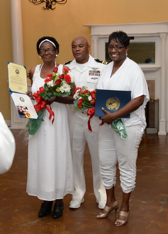 Lt. Cmdr. Donald Mitchell, senior nurse executive, Naval Branch Health Clinic-Albany, aboard Marine Corps Logistics Base Albany, presents Certificates of Appreciation, American flags and roses to his mother, Alberta (left), his wife, Natalie (right), as well as other certificates to scores of other family members and friends during his retirement celebration. Mitchell retired after 30-years of active-duty service in the Navy at a “fair winds” celebration held in his honor at the Orange Park Women’s Club, Orange Park, Florida, May 14.
