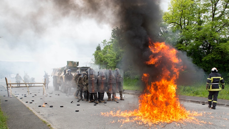U.S. Marines with Special Purpose Marine Air-Ground Task Force-Crisis Response-Africa form a wall of shields as a Molotov cocktail explodes near their feet at the National Gendarmerie Tactical Training Center in Saint-Astier, France, May 13, 2016. The Marines worked closely with the French National Gendarmerie, exchanging riot-control techniques for possible real-world scenarios at embassies around Europe and Africa. 