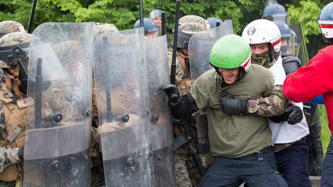 U.S. Marines and members of the French National Gendarmerie hold their ground against rioters to protect a simulated U.S. Embassy during a riot-control exercise at the National Gendarmerie Training Center in St. Astier, France, May 13, 2016. Marines with Special Purpose Marine Air-Ground Task Force-Crisis Response-Africa worked closely with their French counterparts to exchange riot-control techniques while for possible real-world scenarios at embassies around Europe and Africa. 