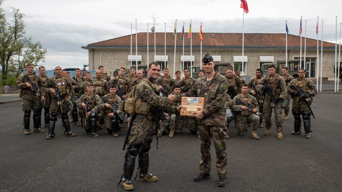 U.S. Marine Corps 1st Lt. Nicholas Berger, a platoon commander with Special Purpose Marine Air-Ground Task Force-Crisis Response-Africa, presents a plaque to the commander of the National Training Center for Gendarmerie Forces at the conclusion of a joint riot control exercise with U.S. Marines in St. Astier, France, May 13, 2016. This exercise helped reinforce the strong relationship between the United States and France and prepared the Marines and Gendarmes to work together in possible real-world scenarios at embassies around Europe and Africa. 