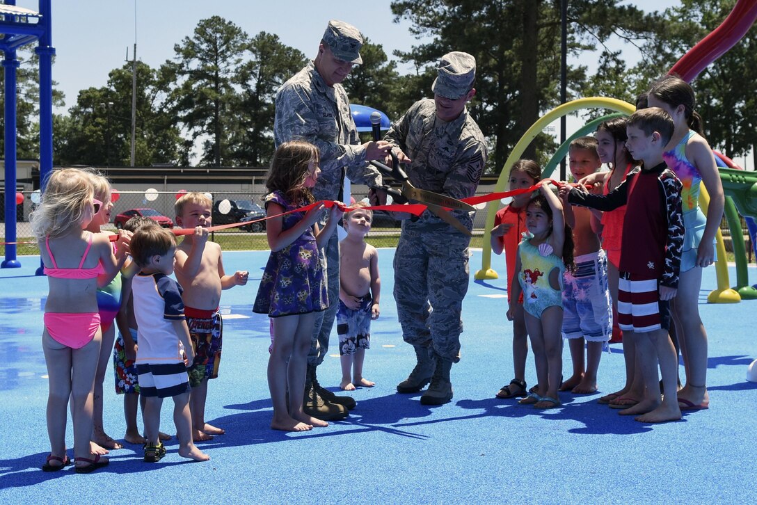Col. Joseph Slavick (center left), 4th Mission Support Group commander, and Chief Master Sgt. Shane Wagner, 4th Fighter Wing command chief, cut the ribbon at the splash pad grand opening, May 24, 2016, at Seymour Johnson Air Force Base, North Carolina. The splash pad is open seven days a week from 9 a.m. to 9 p.m. through Labor Day weekend. (U.S. Air Force photo by Airman Shawna L. Keyes/Released)  
