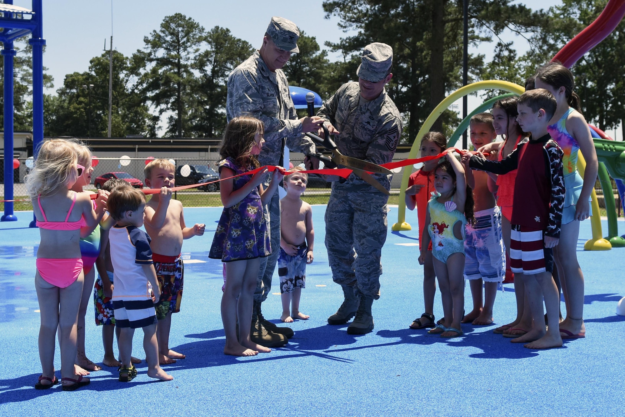 Col. Joseph Slavick (center left), 4th Mission Support Group commander, and Chief Master Sgt. Shane Wagner, 4th Fighter Wing command chief, cut the ribbon at the splash pad grand opening, May 24, 2016, at Seymour Johnson Air Force Base, North Carolina. The splash pad is open seven days a week from 9 a.m. to 9 p.m. through Labor Day weekend. (U.S. Air Force photo by Airman Shawna L. Keyes/Released)  