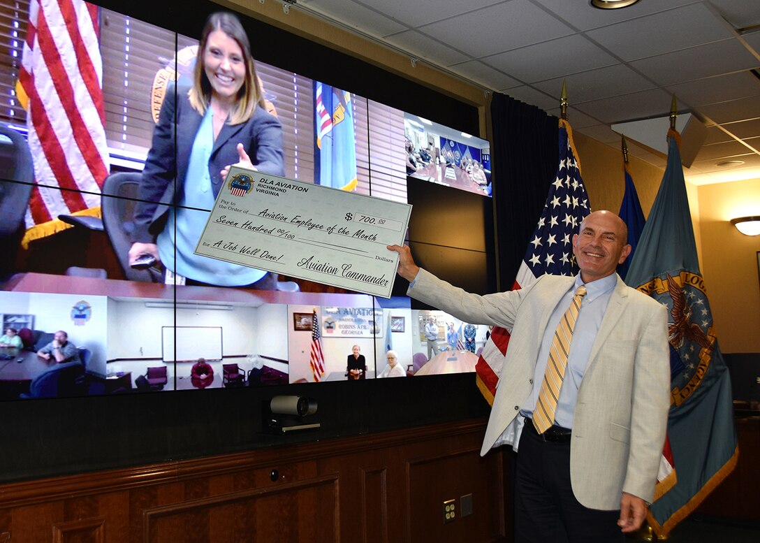 Defense Logistics Agency Aviation at Ogden employee Melissa Small receives a check from DLA Aviation Deputy Commander Charlie Lillie May 19, 2016 in a ceremony honoring her selection as the March 2016 Employee of the Month.