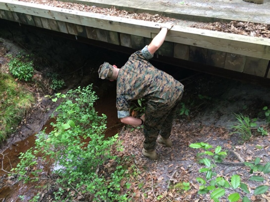 On May 10, 2016 Second Lieutenant Thomas Cofer, attached to Combat Engineer Officer course 5-16 (CEO 5-16); examines the underside (or substructure) of a nonstandard timber bridge. Students with CEO 5-16 were given classes on the design, construction, and employment of these types of bridges.
