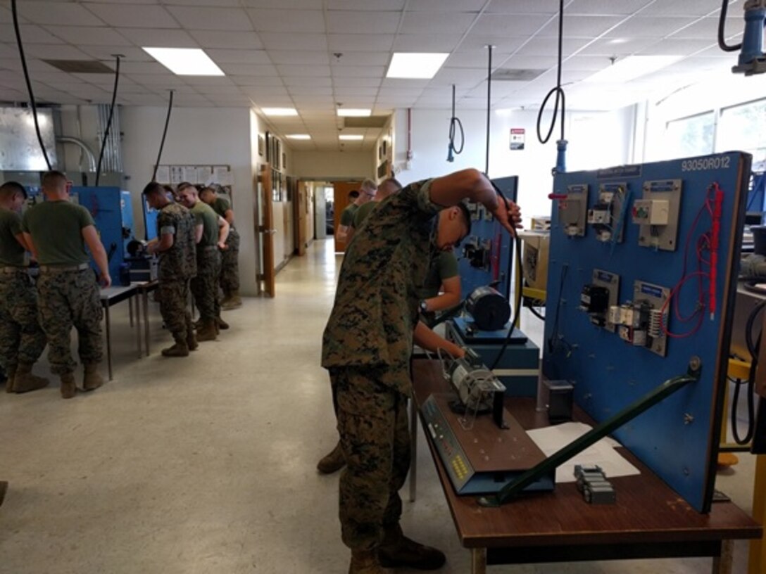 Private First Class Cainin D. Meraz (front), a Marine from Vidor, TX attending Basic Refrigeration and Air Conditioning Technician course 3-16 (BRACT 3-16); attaches a power cable to the electric motors trainer.  BRACT course Marines receive training on the function, associated components, and troubleshooting electric motors.
