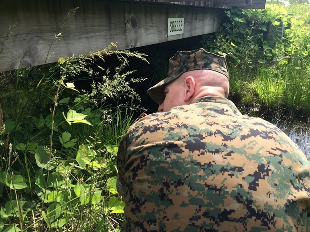 On May 10, 2016 Second Lieutenant Justin Wilkison, a Marine attending Combat Engineer Officer course 5-16 (CEO 5-16); analyzes the substructure of a non-standard bridge at Marine Corps Engineer School aboard Camp Lejeune, N.C. Students in the course receive instruction on how to properly design and construct a variety of bridges.
