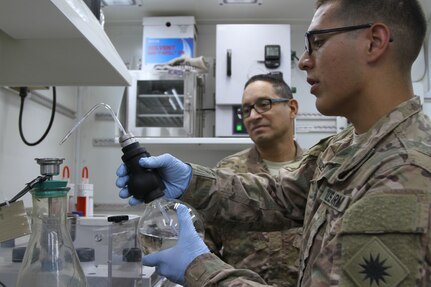 U.S. Army Sgt. 1st Class Luis A. Cotte, petroleum lab certification NCO with the 969th Quartermaster Detachment, 1st Sustainment Command (Theater), back, observes Spc. Christian M. Valencia, petroleum laboratory specialists with Alpha Company, 640th Aviation Sustainment Battalion, 40th Combat Aviation Brigade during the fuel laboratory quarterly inspection, at Camp Arifjan, Kuwait, June 14, 2016. (U.S. Army photo by Sgt. 1st Class Naurys Marte/Released)
