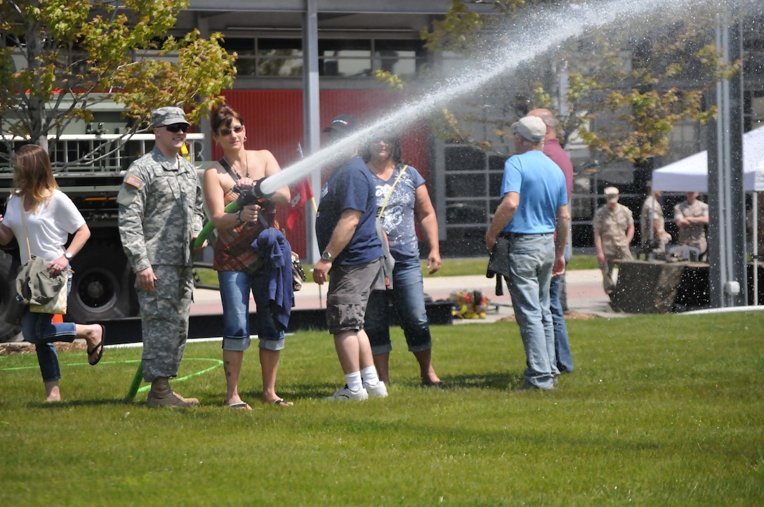 A visitor at the Milwaukee Armed Forces Day experiences a fire house under the supervision of Army engineer, Sgt. Brandon Kutz, 482nd Engineer Detachment, Sturtevant, Wisconsin.