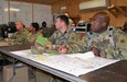 Col. Toni Glover, 650th Regional Support Group commanding officer, and her staff take a brief from Maj. Leopold Karanikolas, 314th Combat Sustainment Support Command commander, and his staff in the Intermediate Staging Base tactical operations center, during Joint Readiness Training Center, Fort Polk, exercises May 7, where units from the U.S. Army National Guard, Army Reserve and active-duty Army train together.