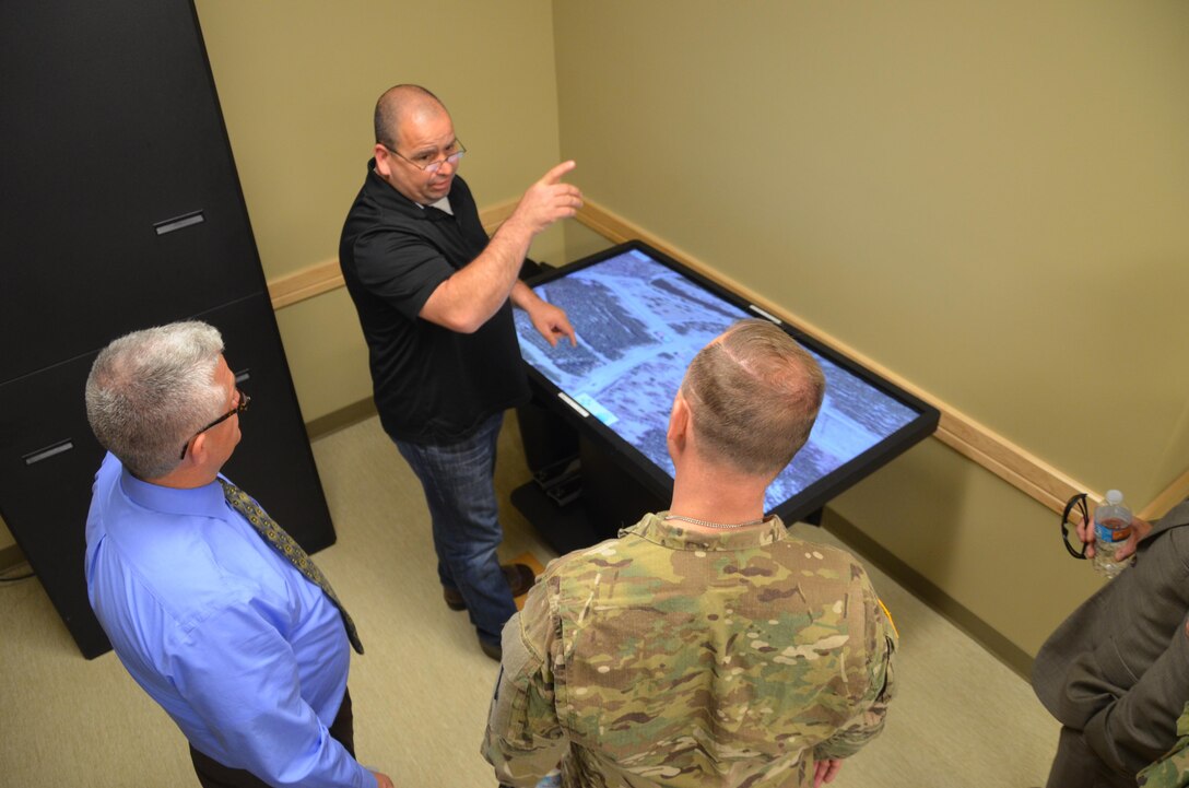 Maj. Gen. Patrick Reinert, Fort McCoy senior commander and 88th Regional Support Command commanding general (right) views the computer technology available to training units during a ground tour of the extensive training capabilities provided by the Range Complex on Fort McCoy, Wis., May 23.