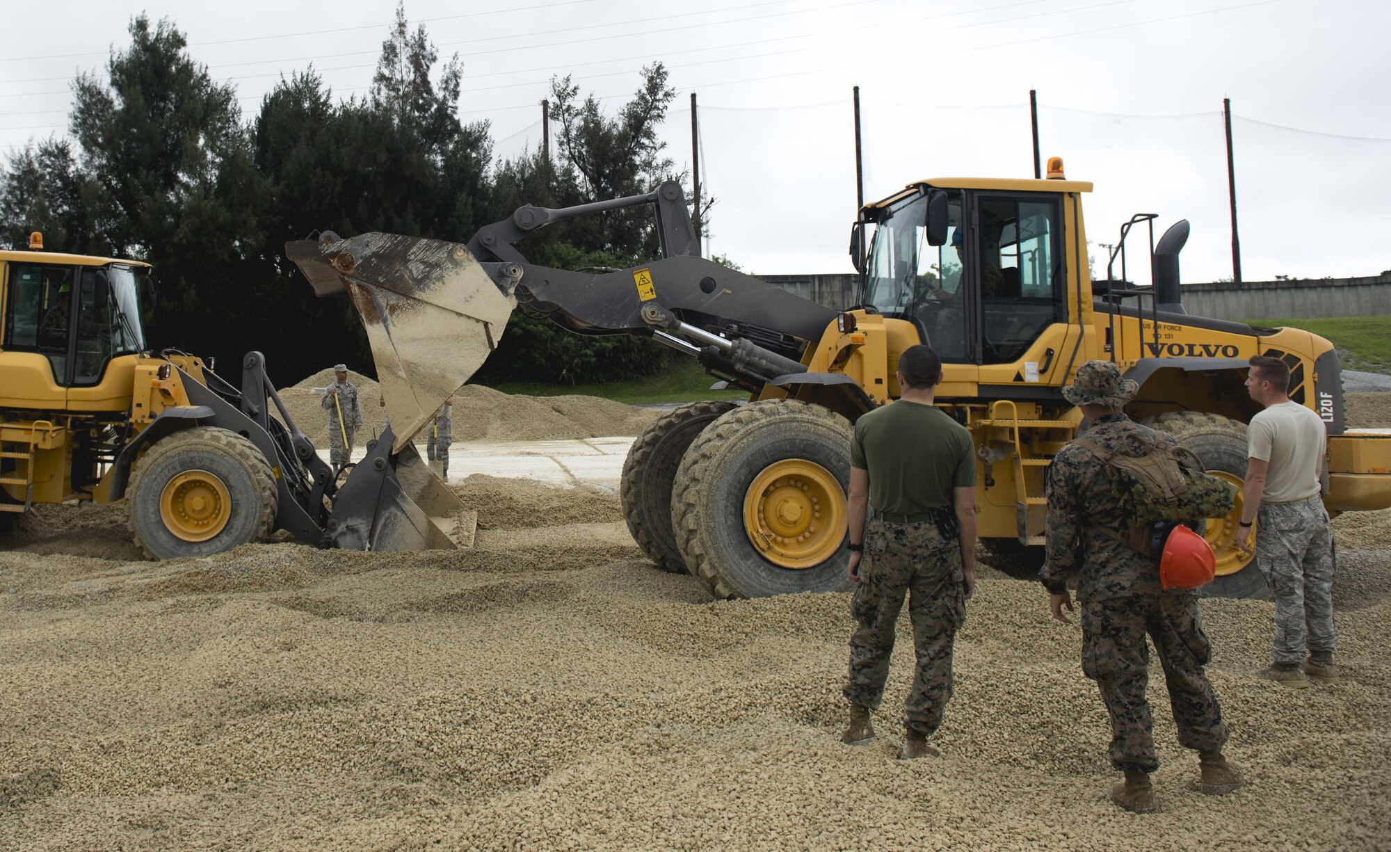Marines fill a 50-foot crater during a two-day joint airfield damage repair exercise May 18, 2016, at Kadena Air Base, Japan. Airmen from the 18th Civil Engineer Squadron taught Marines and Navy Seabees how they repair damaged airfields. (U.S. Air Force photo/Senior Airman Omari Bernard)