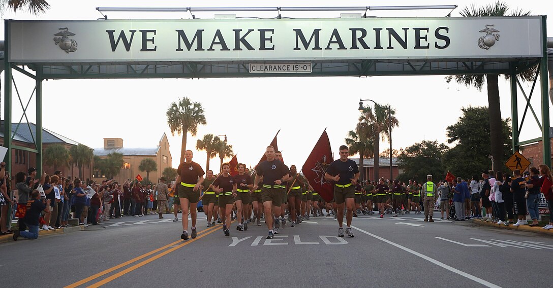 Senior leaders from around Marine Corps Recruit Depot Parris Island lead the new Marines of Mike Company, 3rd Recruit Training Battalion, and November Company, 4th Recruit Training Battalion, under the “We Make Marines” sign during a traditional motivational run Oct. 3, 2013, on MCRD Parris Island, S.C. The Marines sang cadence as they ran 2.3 miles past family and friends. Parris Island has been the site of Marine Corps recruit training since Nov. 1, 1915. Today, approximately 20,000 recruits come to MCRD Parris Island annually for the chance to become United States Marines by enduring 13 weeks of rigorous, transformative training. (Photo by Cpl. Caitlin Brink/Released)