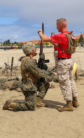 A drill instructor from Bravo Company, 1st Recruit Training Battalion, attaches a bayonet to a recruit’s rifle during the Bayonet Assault Course at Marine Corps Recruit Depot San Diego, May 24. This was the first time the recruits maneuvered through the course with actual bayonets. Annually, more than 17,000 males recruited from the Western Recruiting Region are trained at MCRD San Diego. Bravo Company is scheduled to graduate June 17.