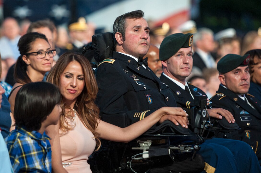 Wounded warrior Romulo Camargo, a retired Army chief warrant officer, and his family listen to the 26th National Memorial Day Concert at the U.S. Capitol in Washington, D.C., May 24, 2015. The concert included musical performances, documentary footage and dramatic readings to honor the fallen and comfort the grieving. DoD photo by Navy Petty Officer 1st Class Daniel Hinton